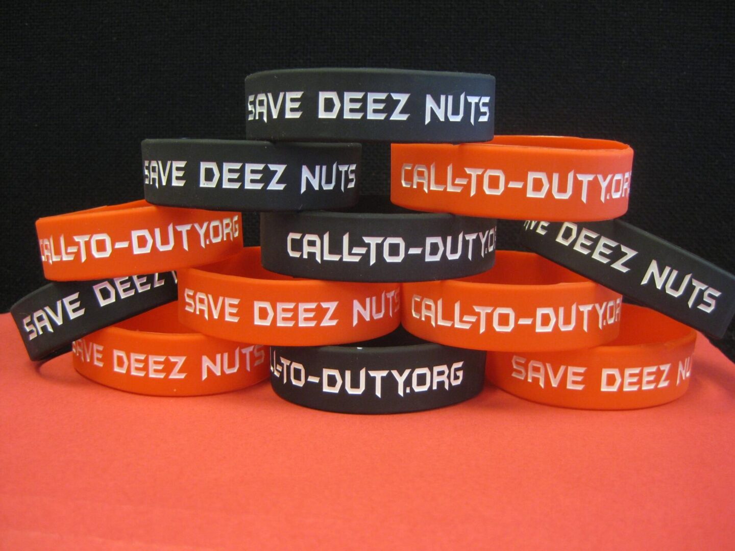 A stack of orange and black Save Deez Nuts wristband 6 pack.