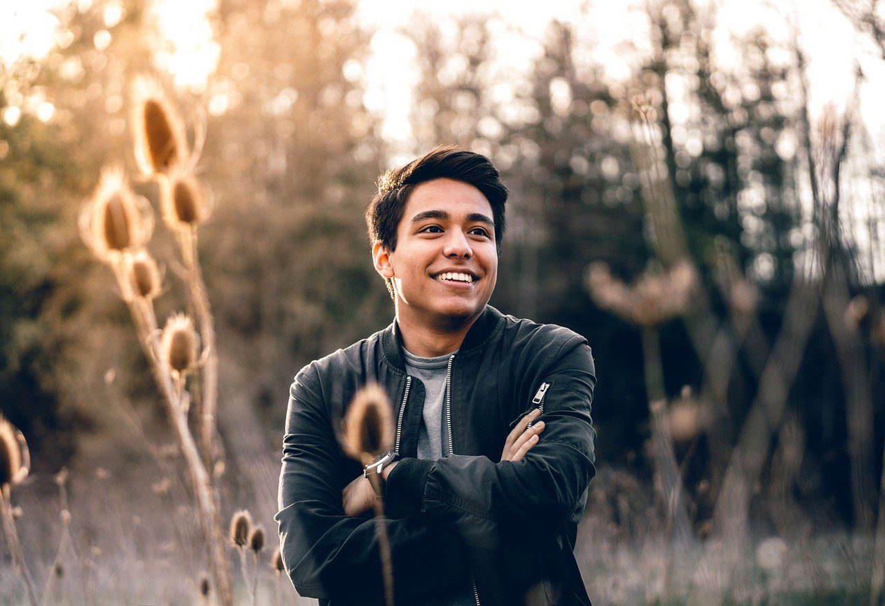 A man standing in a field with tall grasses.