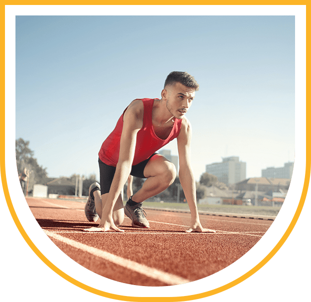 A man crouching on a running track.