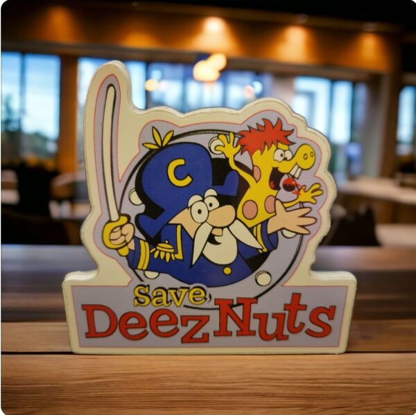 A table adorned with a sign displaying the phrase "Save Deez Nuts Stickers".
